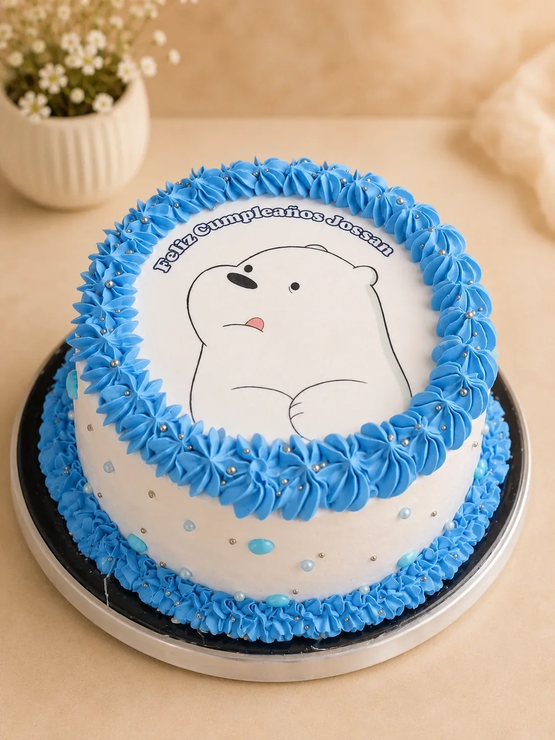 Pastel blanco con bordes azules y una ilustración de personaje.